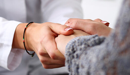 Friendly female doctor hold patient hand in office during recept Friendly female doctor hold patient hand in office during reception. Examination result, positive test, calm down, promise and cheer up, grief and suffer, treatment, condolence, ethics concept